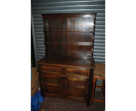 A reproduction Oak Priory style Dresser, having moulded top, two shelf plate rack, the base having plain top, two moulded fro