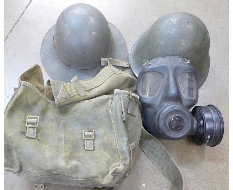 A post war gas mask, a British civil defence helmet and one other helmet