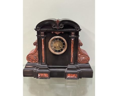 A large Victorian black slate mantle clock, with red marble inserts with a circular dial with Roman numerals and an eight day
