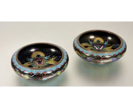 A pair of Chinese Cloisonné shallow bowls, decoarted with scrolling five claw dragons chasing the pearl of wisdom on black gr