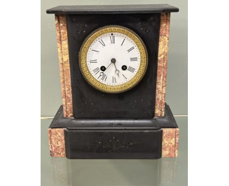 A continental 19th century black slate mantle clock with a circular enamel dial with Roman numerals and an eight day movement