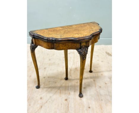 A walnut card table, with a shaped fold over baize lined top, standing on cabriole supports, 74cm x 84cm x 42cm 
