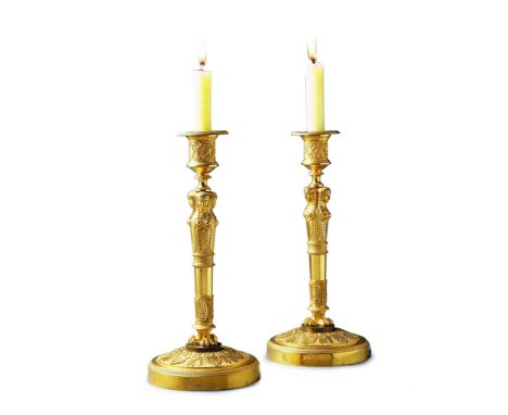 A Pair of Empire Gilt Bronze Candlesticks France circa 1810, the socles enriched with machined neo-classical ornament with a 