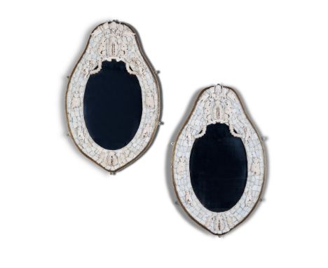 A Pair of Dieppe Mirrors France circa 1880, the oval plates within an applied carved ivory frame decorated with a coat of arm