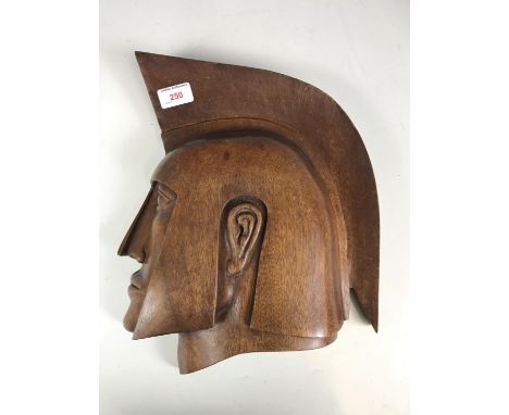 A vintage carved wall plaque in the form of the profile of a Greek warrior