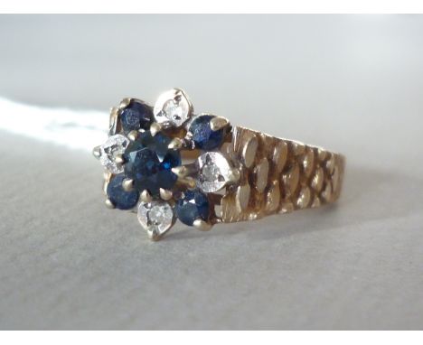 A vintage 9ct gold sapphire and diamond cocktail ring, in a flower head cluster arrangement, flanked by bark effect shoulders