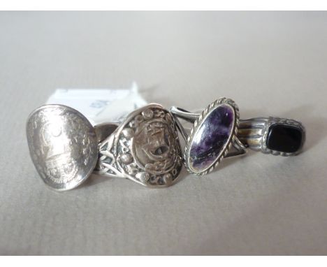 Four vintage white metal rings, including one set with amethyst and one made from a 1918 threepenny piece