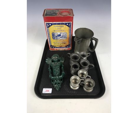 Pewter measures together with advertising tins and a cherub door knocker