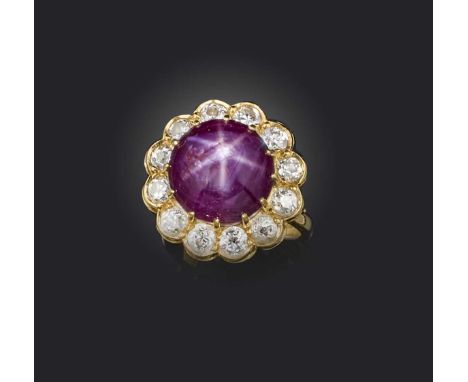 A ruby and diamond cluster ring, the star ruby cabochon set within a surround of circular-cut diamonds in 18ct yellow gold, s