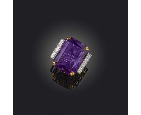 An amethyst and diamond cocktail ring, set with a large mixed cut amethyst, to shoulders channel-set with baguette diamonds, 