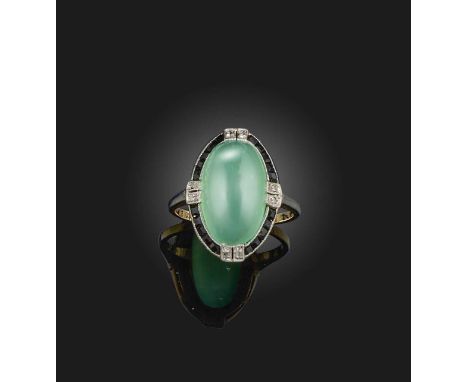 An Art Deco chrysoprase, onyx and diamond ring, 1920s, set with a chrysoprase cabochon, within a border of calibré-cut onyx, 