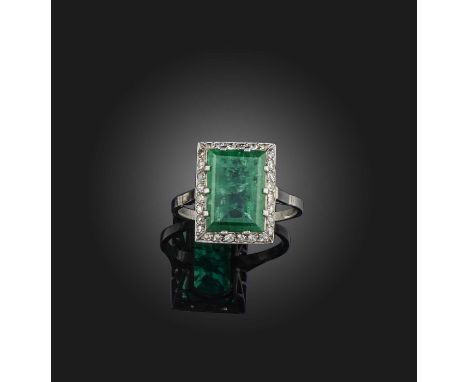 An emerald and diamond ring, early 20th century, claw-set with a step-cut emerald weighing approximately 3.00 carats, within 