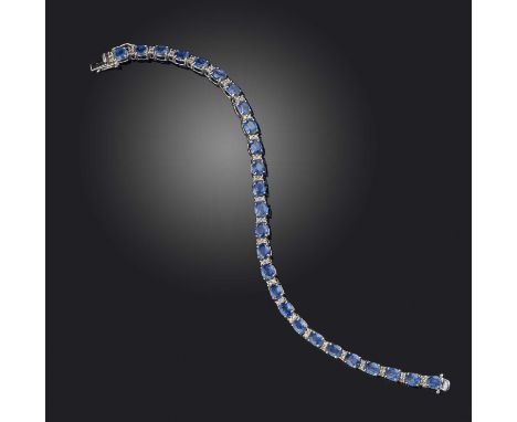 A sapphire and diamond line bracelet, designed as a line of oval sapphires totalling 11.29 carats, spaced with brilliant-cut 