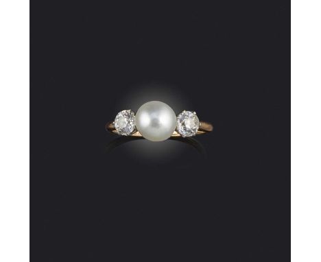 A natural pearl and diamond three-stone ring, set with a central button-shaped white pearl weighing 3.45 carats, flanked with