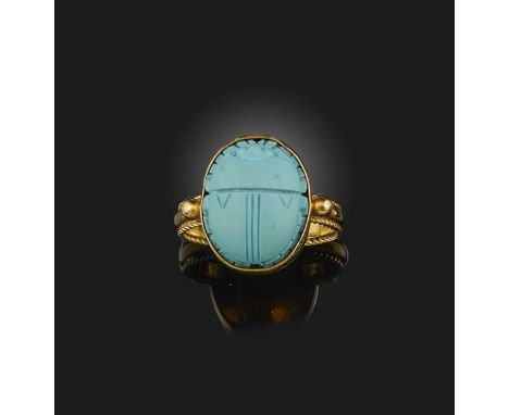 A gold and reconstituted turquoise ring, designed in the Egyptian revival style, set with a carved scarab in reconstituted tu