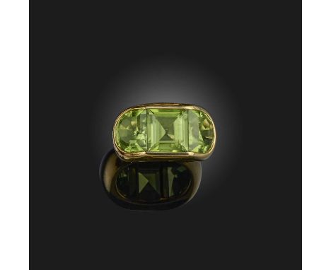 A peridot ring, channel-set with a square step-cut peridot between two demi-lune peridots, mounted in gold, size L1/2