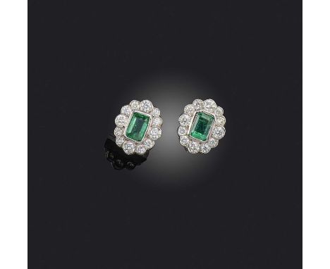 A pair of emerald and diamond earrings, of cluster design, set with step-cut emeralds totalling 1.10 carats within borders of