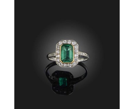 An emerald and diamond ring early 20th century, set with a step-cut emerald weighing approximately 1.00 carat, within a borde