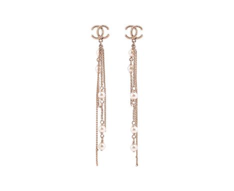 Chanel - a pair of tassel earrings, circa 2019, each featuring a gold-tone textured CC logo motif surmount, dangling with whe