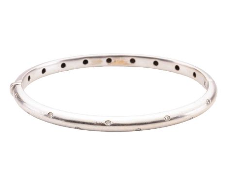 A diamond-set hinged bangle, the court-shaped bangle measuring approximately 4.75mm wide and flush-set with twenty round bril