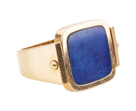 A swivel dress ring set with lapis lazuli; the cushion-shaped swivel ring head decorated with an armorial crest with vacant s