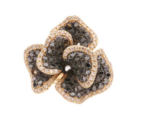A white and black diamond set stylised floral dress ring, featuring pave set round black and white diamonds into sculptural r