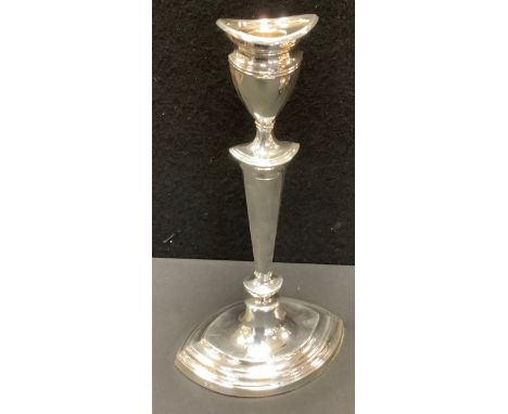 A silver Neo-Classical style candle stick of navette shape, detachable nozzle, vasular sconce, tapered nipped column, stepped