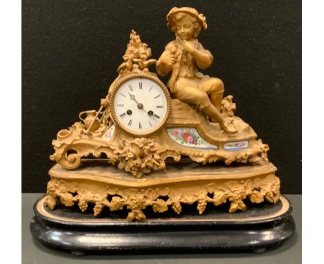 A 19th century French Louis XVI style ormolu and porcelain mantel clock, the case cast as a seated farm boy with floral rimme