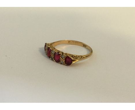 An attractive ruby and diamond ten stone ring in carved mount. Approx. 4.3 grams. Est. £250 - £350.