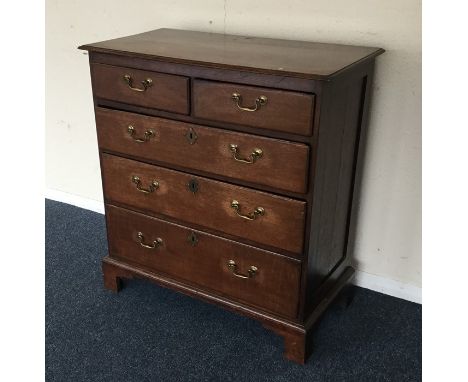 An Antique oak chest of three long and two short drawers on bracket feet. Est. £40 - £60.