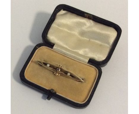 A small garnet and pearl boat shaped brooch in 15 carat gold. Approx. 1.3 grams. Est. £35 - £40.