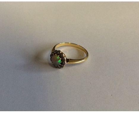 A Victorian opal and diamond circular cluster ring in two colour gold. Approx. 3.4 grams. Est. £100 - £150.
