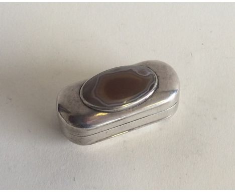 An oval silver snuff box with central agate. Punched to interior, 'TW'. Approx. 27 grams. Est. £100 - £150.