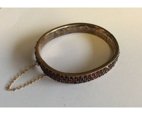 An Antique three row garnet bangle with concealed clasp. Est. £70 - £80.