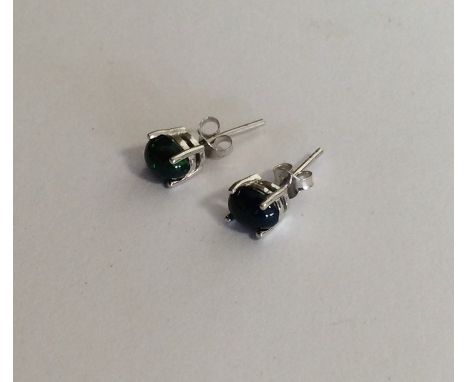 A pair of black opal ear studs in claw mounts. Est. £60 - £80.