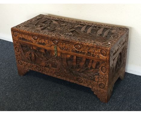 A carved camphor wood trunk of typical design. Est. £30 - £50.