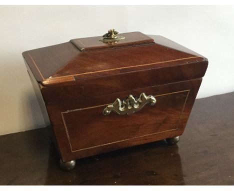 A Georgian mahogany sarcophagus shaped tea caddy on brass feet. Est. £25 - £35.