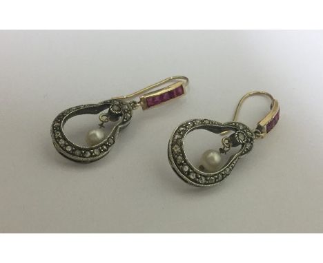 An attractive pair of large ruby and diamond earrings of shaped form with pearl drops set in silver and gold. Approx. 5.5 gra