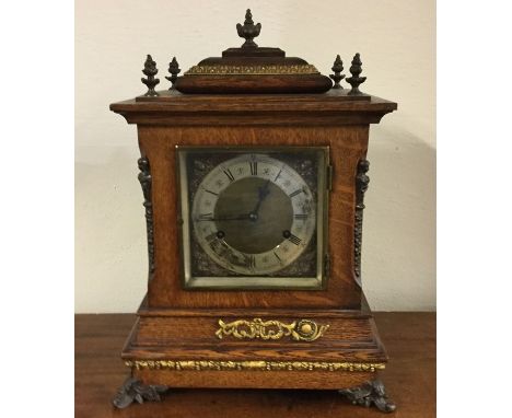 A large oak cased bracket clock with silvered dial and ormolu mounts. Est. £100 - £150.