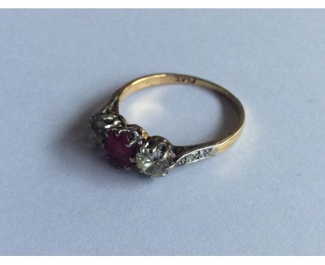 A large ruby and diamond three stone ring in 18 carat and platinum mount. Approx. 3.3 grams. Est. £300 - £400.