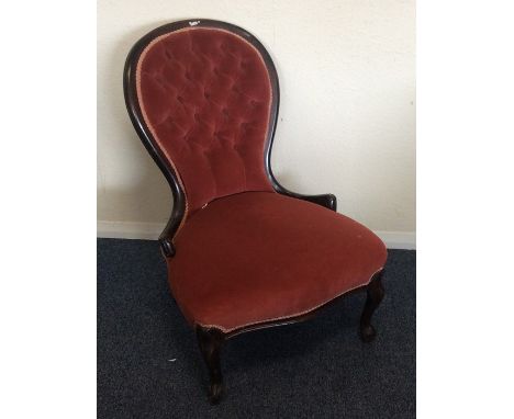 A pink button back nursing chair. Est. £30 - £50.
