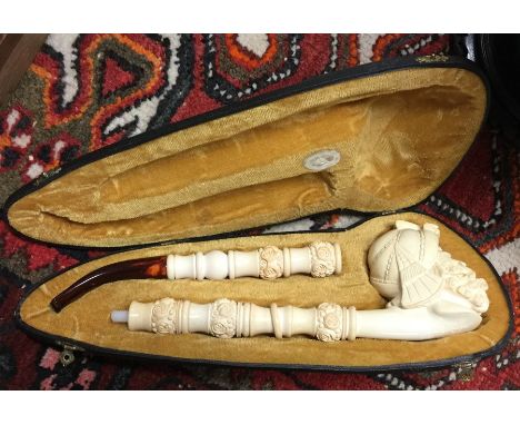 A cased bone mounted pipe carved with a figure. Est. £40 - £60.