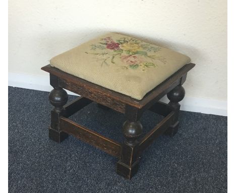 A small oak stool with tapestry seat. Est. £20 - £30.