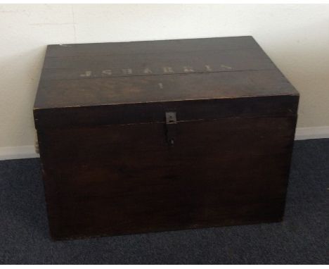 A hardwood hinged top trunk. Est. £30 - £50.