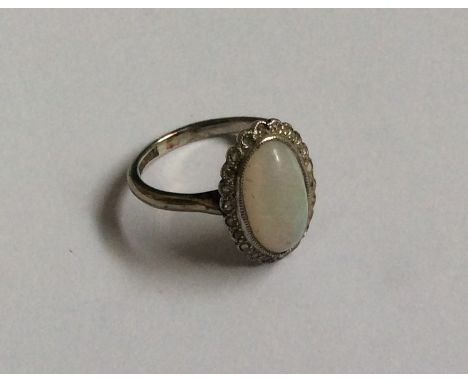 A good oval opal and diamond cluster ring in platinum claw mount. Approx. 3.7 grams. Est. £250 - £350.