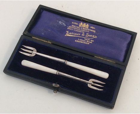 An Edwardian silver tapering spoon and fork contained within a box. Approx. 13 grams. Est. £35 - £40.