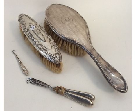 A silver mounted brush together with a button hook etc. Est. £15 - £20.