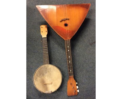 A cased banjo together with a balalaika. Est. £30 - £50.
