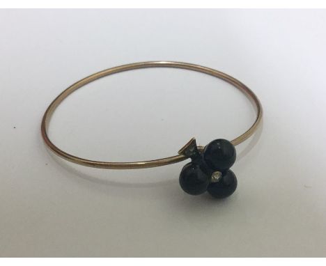 An Antique onyx and diamond bangle in the form of a clover. Approx. 6.2 grams. Est. £100 - £200.