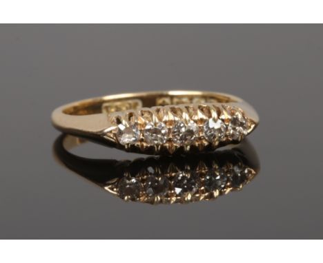 An 18ct gold five stone diamond ring in boat shaped setting. Set with five old European cut diamonds graduating in size. Assa